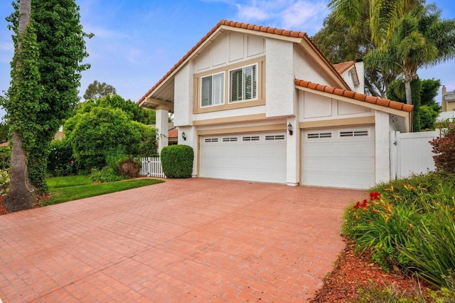2702 Jacaranda Ave, Carlsbad, CA 92009 - view of front of home with decorative driveway, stucco siding, a tiled roof, and an attached garage
