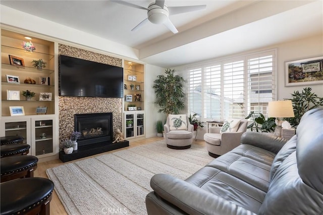 1939 Circle Dr, Cayucos, CA 93430 - living room featuring a ceiling fan, wood finished floors, a glass covered fireplace, and built in shelves