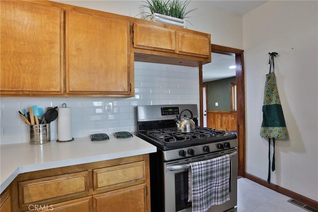 2548 Secret Dr, Running Springs, CA 92382 - kitchen featuring gas stove, tasteful backsplash, light countertops, and brown cabinetry