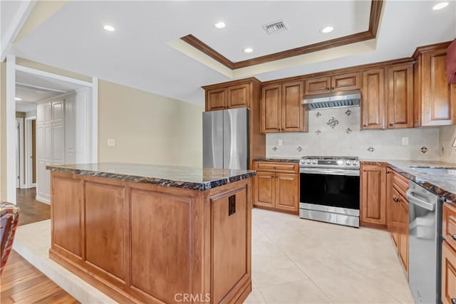 20002 Tomlee Ave, Torrance, CA 90503 - kitchen with stainless steel appliances, under cabinet range hood, a raised ceiling, a center island, and decorative backsplash