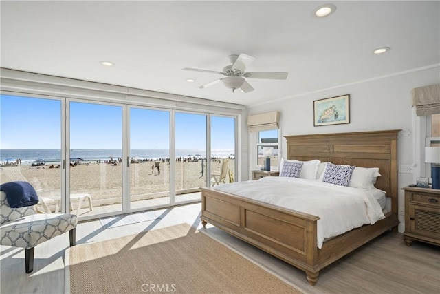 3312 W Oceanfront, Newport Beach, CA 92663 - bedroom with access to exterior, a water view, recessed lighting, light wood-style flooring, and a ceiling fan