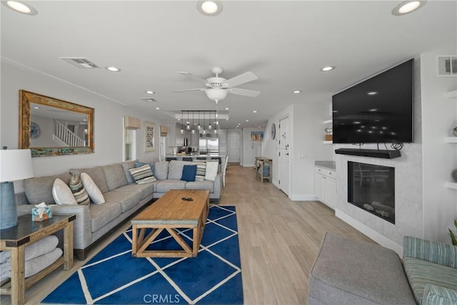 3312 W Oceanfront, Newport Beach, CA 92663 - living area with ceiling fan, a glass covered fireplace, light wood-style flooring, and recessed lighting