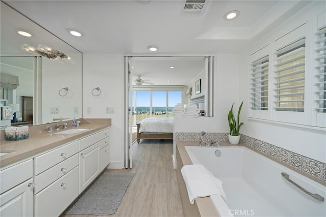 3312 W Oceanfront, Newport Beach, CA 92663 - ensuite bathroom featuring double vanity, a bath, recessed lighting, a ceiling fan, and wood finished floors