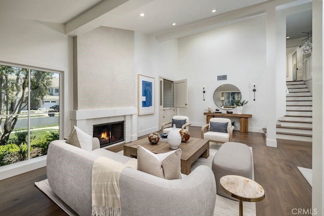 1933 Port Bristol Cir, Newport Beach, CA 92660 - living area with a high ceiling, wood finished floors, a warm lit fireplace, recessed lighting, and stairs