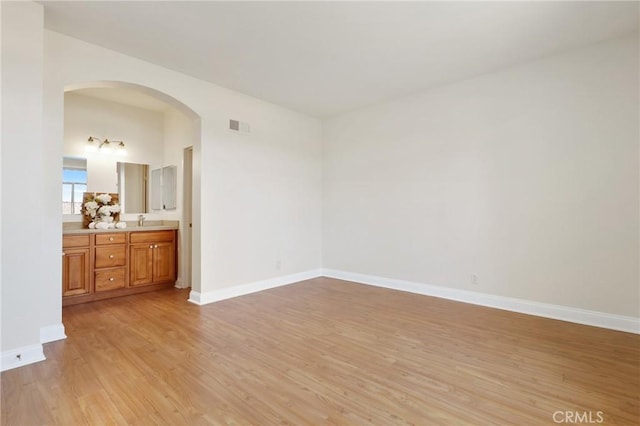 30902 Clubhouse Dr Unit 17A, Laguna Niguel, CA 92677 - unfurnished bedroom with light wood finished floors, arched walkways, and ensuite bath