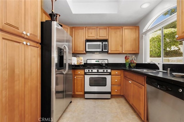 30902 Clubhouse Dr Unit 17A, Laguna Niguel, CA 92677 - kitchen with appliances with stainless steel finishes, dark countertops, light tile patterned floors, a skylight, and recessed lighting