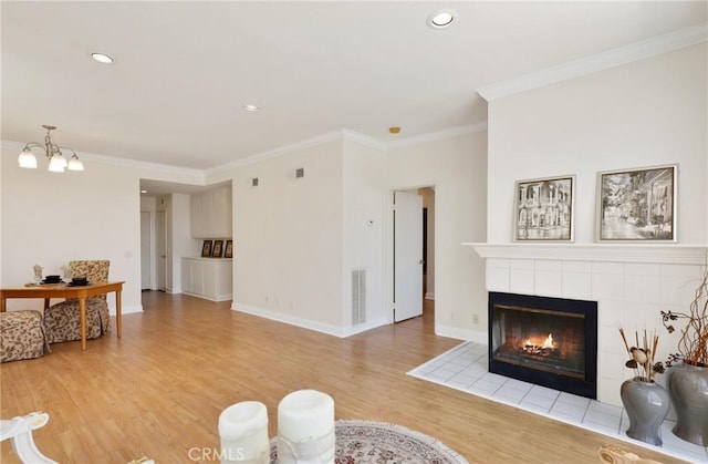 30902 Clubhouse Dr Unit 17A, Laguna Niguel, CA 92677 - living area with light wood finished floors, a tile fireplace, ornamental molding, recessed lighting, and a chandelier