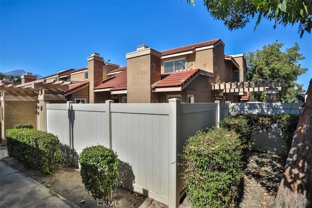 8366 Gabriel Dr Unit D, Rancho Cucamonga, CA 91730 - view of side of home featuring a tiled roof, a pergola, and a chimney