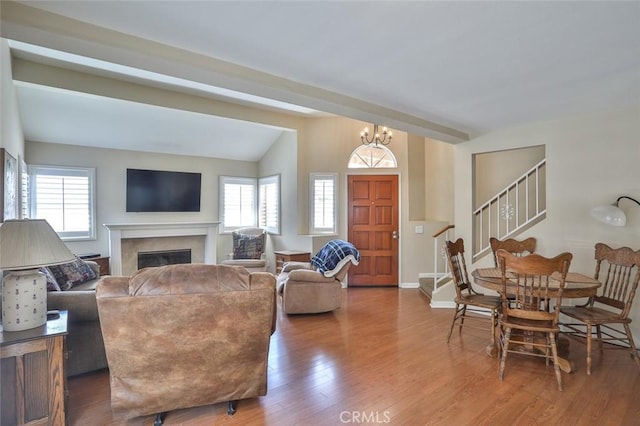 8366 Gabriel Dr Unit D, Rancho Cucamonga, CA 91730 - living area featuring wood finished floors, stairway, a glass covered fireplace, lofted ceiling, and a chandelier