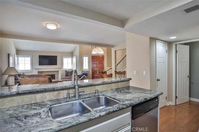 8366 Gabriel Dr Unit D, Rancho Cucamonga, CA 91730 - kitchen featuring stainless steel dishwasher, wood finished floors, a fireplace, stone counters, and open floor plan