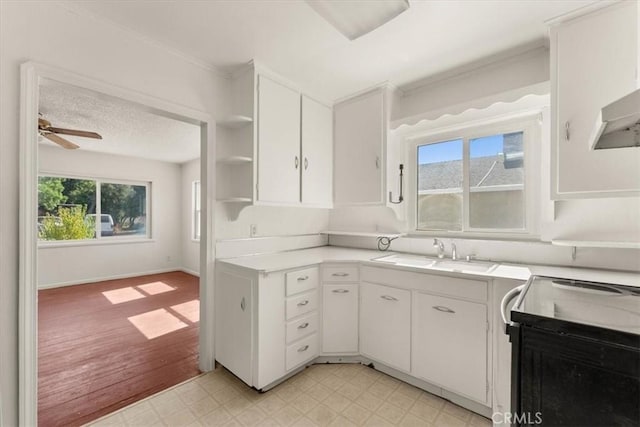 1550 Kaufman Ave, Corning, CA 96021 - kitchen with electric range, open shelves, light flooring, white cabinetry, and light countertops