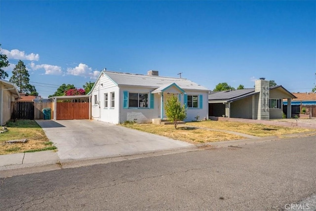 1550 Kaufman Ave, Corning, CA 96021 - view of front of home with concrete driveway, roof mounted solar panels, and a chimney