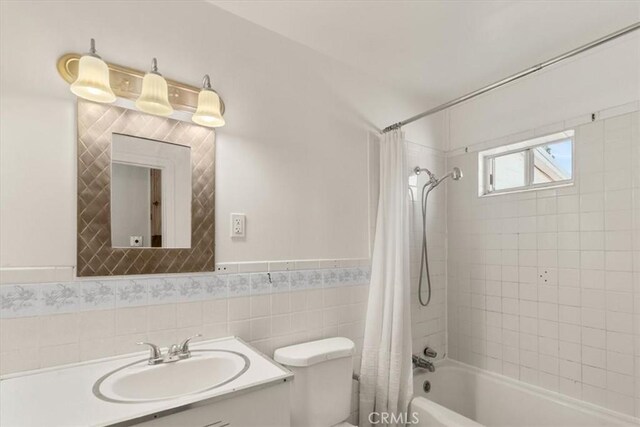 1550 Kaufman Ave, Corning, CA 96021 - full bath featuring shower / bathtub combination with curtain, vanity, a wainscoted wall, and tile walls