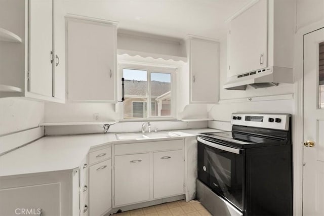 1550 Kaufman Ave, Corning, CA 96021 - kitchen with electric range, under cabinet range hood, light countertops, white cabinetry, and crown molding