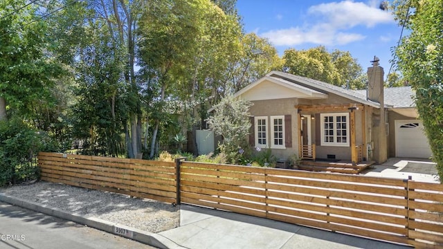 5907 Cantaloupe Ave, Valley Glen, CA 91401 - view of front of property featuring a fenced front yard, stucco siding, an attached garage, and a chimney