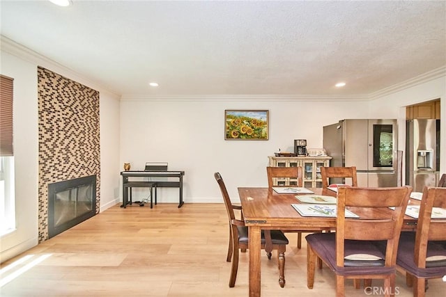 5574 Elsinore Ave, Buena Park, CA 90621 - dining room with crown molding, light wood-style flooring, a fireplace, and recessed lighting