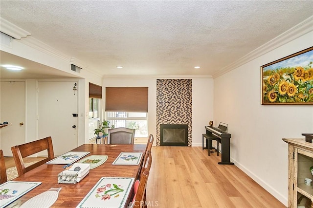 5574 Elsinore Ave, Buena Park, CA 90621 - dining room featuring a tile fireplace, a textured ceiling, light wood-style floors, crown molding, and recessed lighting