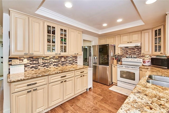 5574 Elsinore Ave, Buena Park, CA 90621 - kitchen featuring stainless steel appliances, cream cabinetry, under cabinet range hood, a tray ceiling, and tasteful backsplash