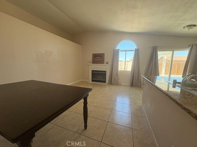 10810 Euclid St, Adelanto, CA 92301 - unfurnished living room featuring light tile patterned flooring, a tile fireplace, and lofted ceiling