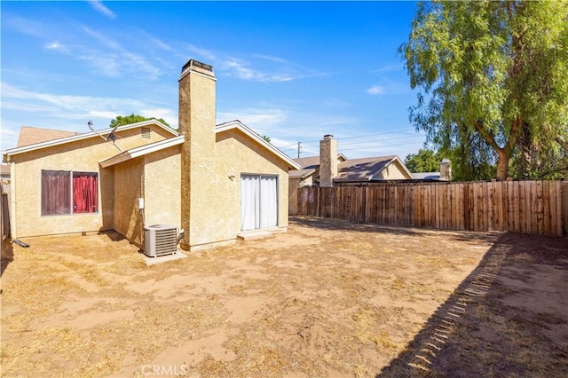37158 29th St E, Palmdale, CA 93550 - back of house with stucco siding, a fenced backyard, and a chimney