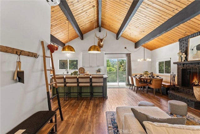 1016 Berne Dr, Crestline, CA 92325 - living area featuring a wooden ceiling with exposed beams, wood finished floors, plenty of natural light, a fireplace, and a chandelier