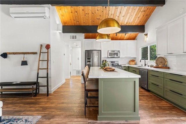 1016 Berne Dr, Crestline, CA 92325 - kitchen featuring green cabinets, stainless steel appliances, a wall unit AC, decorative backsplash, and white cabinetry