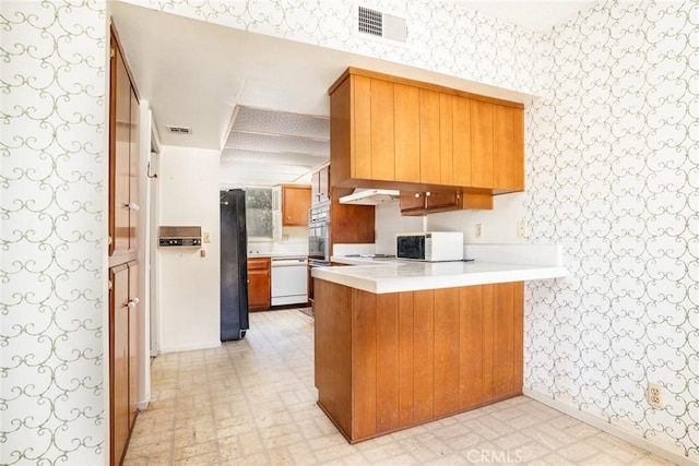 448 Via El Chico, Redondo Beach, CA 90277 - kitchen featuring wallpapered walls, white appliances, a peninsula, light countertops, and brown cabinets