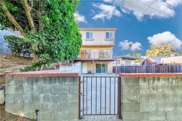 1742 Hanscom Dr, South Pasadena, CA 91030 - back of property with a gate, a fenced front yard, stucco siding, and a balcony