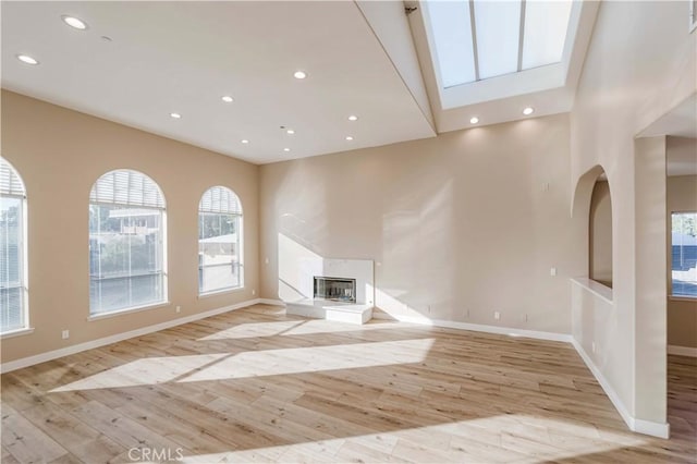 1742 Hanscom Dr, South Pasadena, CA 91030 - unfurnished living room with light wood finished floors, a glass covered fireplace, recessed lighting, and a skylight