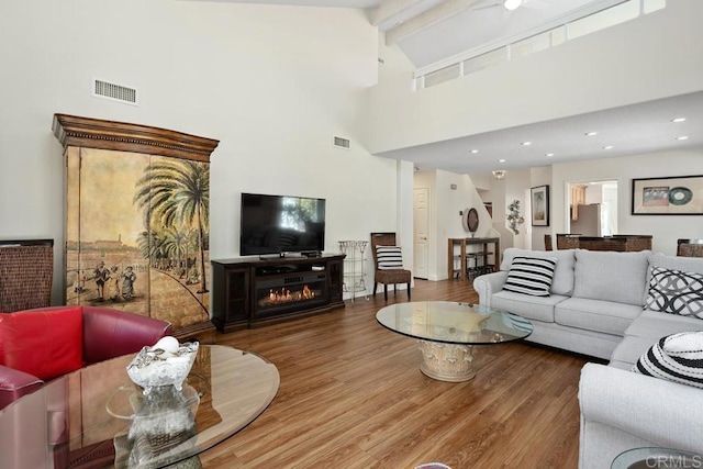 4763 Miletus Way, Oceanside, CA 92056 - living room featuring wood finished floors, beam ceiling, high vaulted ceiling, and a glass covered fireplace