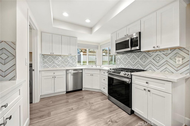 4021 Pikes Peak Dr, Norco, CA 92860 - kitchen with stainless steel appliances, decorative backsplash, light wood finished floors, white cabinetry, and recessed lighting
