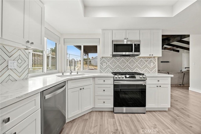 4021 Pikes Peak Dr, Norco, CA 92860 - kitchen with appliances with stainless steel finishes, backsplash, light wood-type flooring, white cabinetry, and light stone countertops
