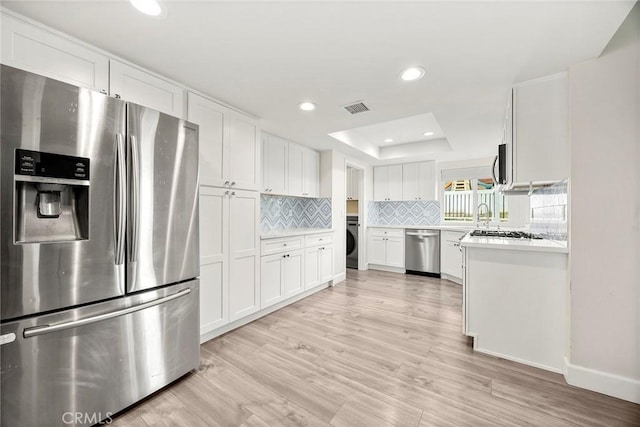 4021 Pikes Peak Dr, Norco, CA 92860 - kitchen with stainless steel appliances, a tray ceiling, decorative backsplash, light countertops, and white cabinets
