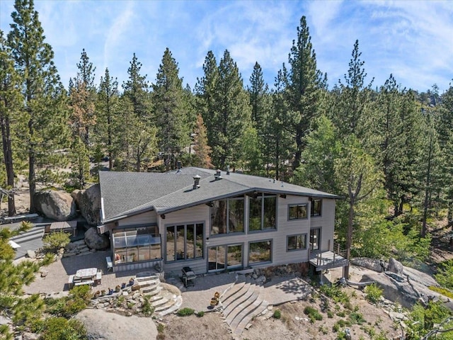 1082 Mountain Canary Dr, South Lake Tahoe, CA 96150 - back of house with a sunroom, a patio area, a view of trees, and a shingled roof