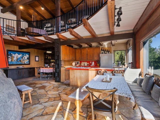 1082 Mountain Canary Dr, South Lake Tahoe, CA 96150 - dining space with plenty of natural light, stone flooring, a wooden ceiling with exposed beams, high vaulted ceiling, and wood walls