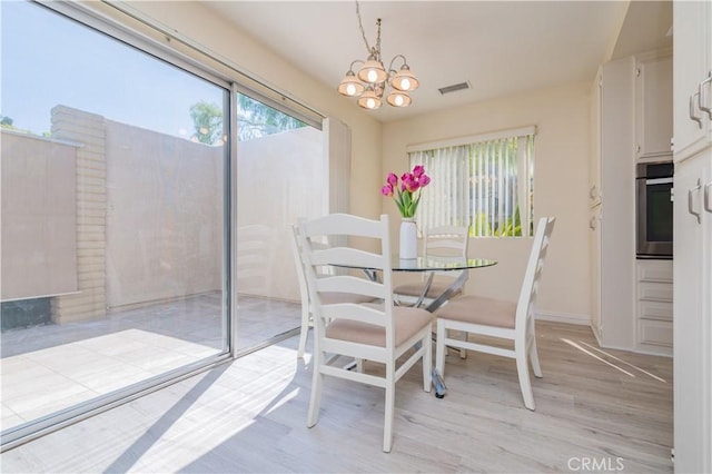 2245 Via Mariposa E Unit D, Laguna Woods, CA 92637 - dining room with light wood-style flooring and a chandelier