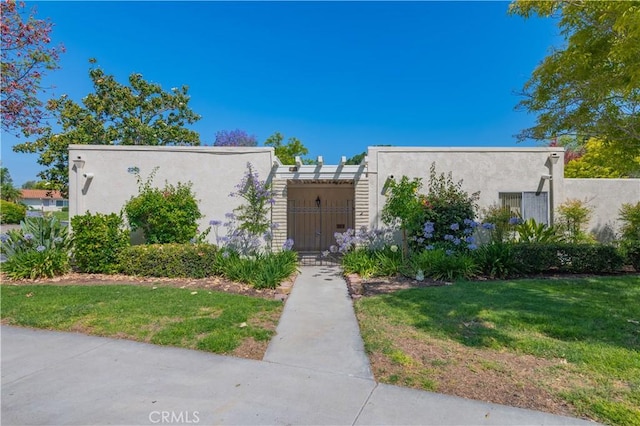 2245 Via Mariposa E Unit D, Laguna Woods, CA 92637 - multi unit property with stucco siding, a front yard, and a gate