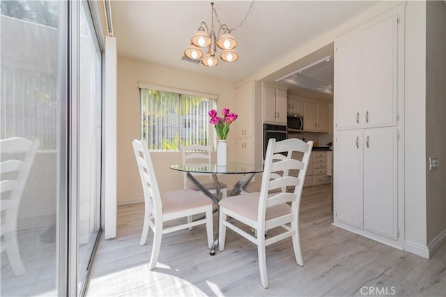 2245 Via Mariposa E Unit D, Laguna Woods, CA 92637 - dining space with light wood-style flooring and a chandelier