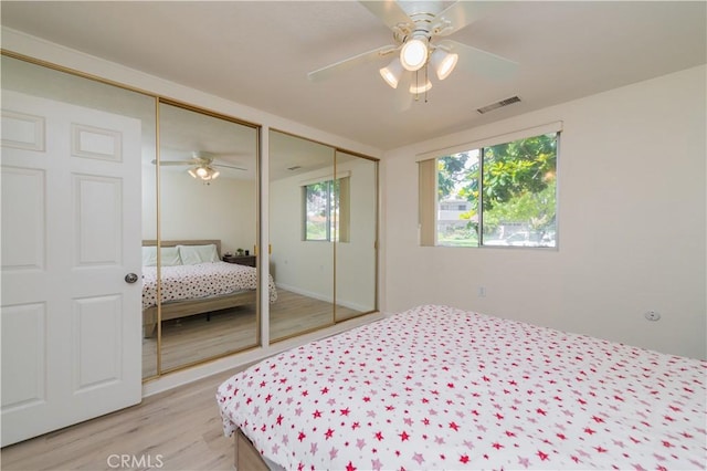 2245 Via Mariposa E Unit D, Laguna Woods, CA 92637 - bedroom featuring multiple closets, light wood-style flooring, and ceiling fan