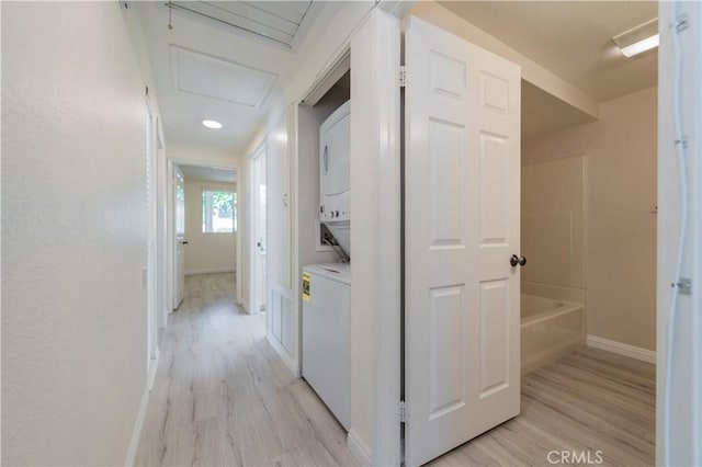 2245 Via Mariposa E Unit D, Laguna Woods, CA 92637 - laundry area with stacked washing machine and dryer, light wood-type flooring, and attic access