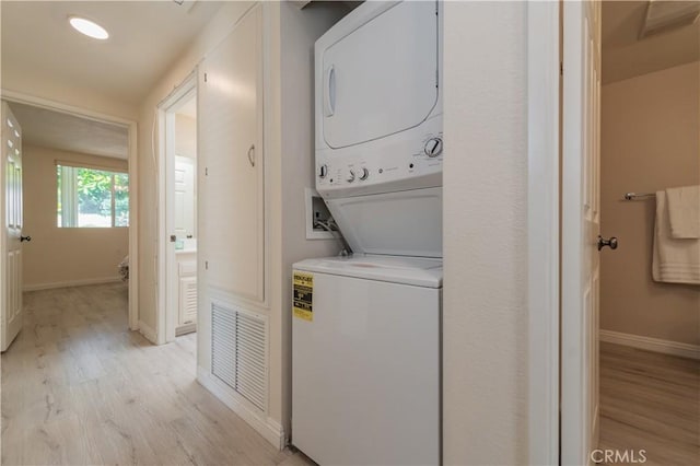 2245 Via Mariposa E Unit D, Laguna Woods, CA 92637 - laundry area featuring stacked washer / dryer and light wood finished floors