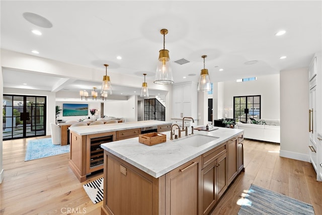 1963 Port Edward Pl, Newport Beach, CA 92660 - kitchen with open floor plan, a kitchen island with sink, wine cooler, light wood-type flooring, and recessed lighting