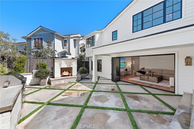 1963 Port Edward Pl, Newport Beach, CA 92660 - rear view of property with a warm lit fireplace, a patio area, and exterior kitchen