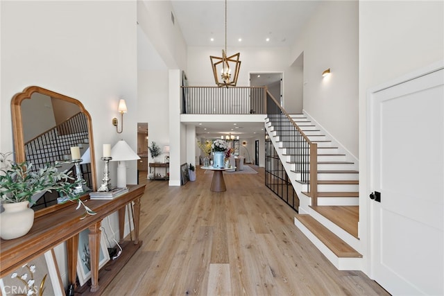 1963 Port Edward Pl, Newport Beach, CA 92660 - foyer entrance featuring a chandelier, a towering ceiling, stairs, wood finished floors, and recessed lighting