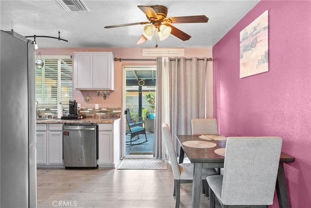1504 Valaria Dr, Highland, CA 92346 - kitchen with appliances with stainless steel finishes, ceiling fan, light wood-style floors, white cabinetry, and a textured wall