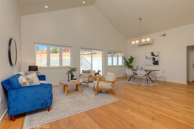 5351 Filbert St, Paradise, CA 95969 - living room featuring high vaulted ceiling, a wall mounted AC, wood finished floors, plenty of natural light, and recessed lighting