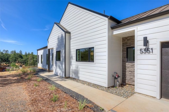 5351 Filbert St, Paradise, CA 95969 - view of side of property featuring a standing seam roof, a metal roof, and stone siding