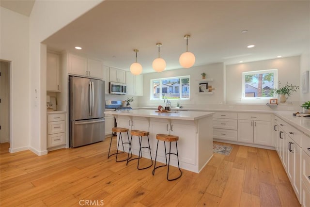 5351 Filbert St, Paradise, CA 95969 - kitchen with appliances with stainless steel finishes, white cabinets, a kitchen bar, recessed lighting, and light countertops