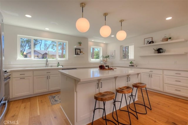 5351 Filbert St, Paradise, CA 95969 - kitchen with a center island, light countertops, a kitchen breakfast bar, white cabinetry, and recessed lighting