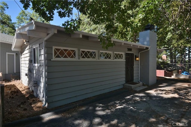 30607 Live Oak Dr, Running Springs, CA 92382 - view of side of home featuring a chimney and a garage